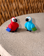 Two vibrant 3D printed parrots, a red one and a blue one, perched on a textured stone surface. 🦜✨ #3DPrintedAnimals